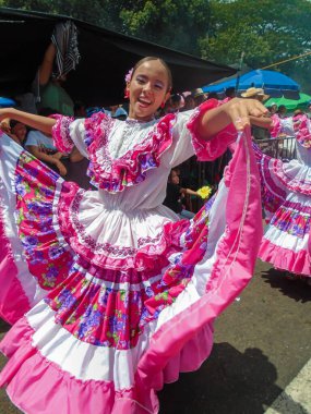 Neiva, Huila, Kolombiya - 30 Haziran 2024 - Pembe elbiseli, gülümseyen ve kameraya bakan genç Latin kadın