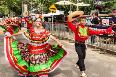 Neiva, Huila, Kolombiya - 27 Haziran 2024 Latin çocuklar neşeyle dans ediyor ve geçit töreninde kameraya bakıyorlar.