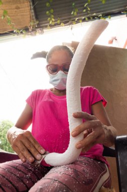 White Latina woman with glasses working on a styrofoam mold clipart