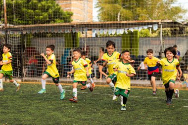 Neiva-Huila-Kolombiya sentetik mahkemesinde koşan mutlu Latin çocuklar