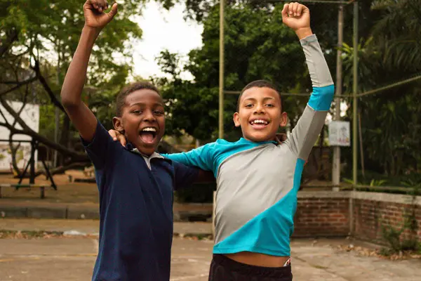 stock image Black Latino children with their arms up celebrating a goal on a park field in Neiva - Huila - Colombia