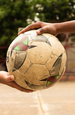 Neiva-Huila-Kolombiya parkında eski bir topu tutan Latin çocukların elleri.