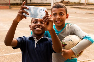 Neiva-Huila-Kolombiya 'da bir parkta selfie çeken neşeli Latin çocukların portresi.