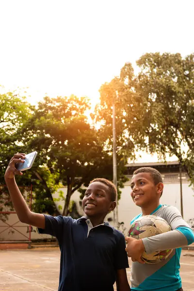 Neiva-Huila-Kolombiya parkında akıllı telefonla fotoğraf çeken siyahi Latin çocuklar.