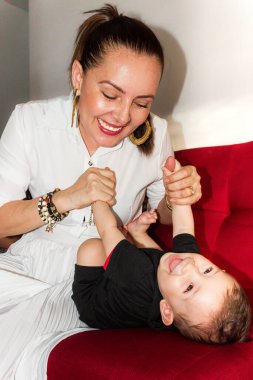 Neiva-Huila-Kolombiya 'da küçük oğlunun ellerine dokunan mutlu Latin anne. Annelik kavramı