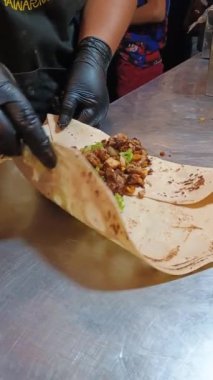Siyah eldivenli tanınmayan Latin kadın Neiva Huila Kolombiya 'da bir restoranda etli taco hazırlıyor. Meksika yemeği konsepti