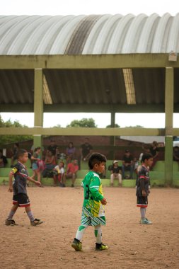 Neiva-Huila-Kolombiya 'daki bir kum tarlasında yeşil üniformalı bir Latin çocuk futbol maçında. Spor ve çocukluk kavramı