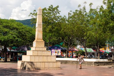 Tocaima - Cundinamarca - Kolombiya - 20 Ekim 2024 - Kasaba parkında yürüyen yaşlı kadın