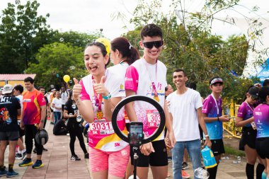 Neiva, Huila, Colombia, - November 23, 2024 - Latina woman looking at camera while running in a marathon on an avenue clipart