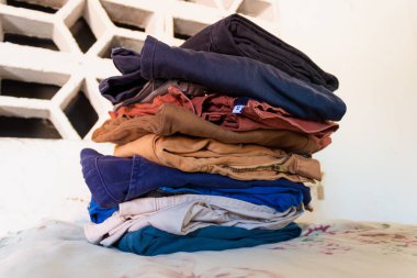 Neiva - Huila - Kolombiya 'daki bir evin içindeki masaya ütülenmeye hazır renkli kot kulesi. Ev işi kavramı