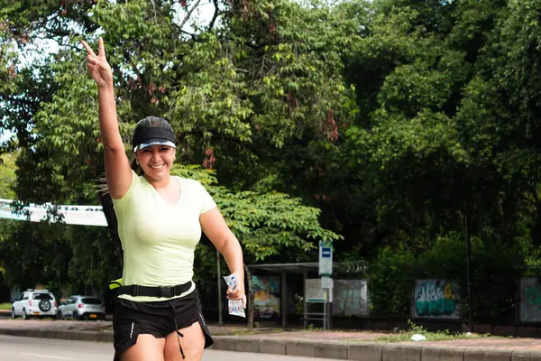 Neiva, Huila, Kolombiya, - 23 Kasım 2024 Bir bulvarda maraton koşarken kameraya bakan Latin kadın
