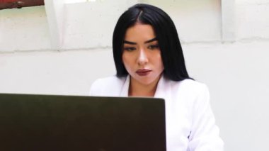 Neiva Huila Kolombiya 'da bir restoranın içinde dizüstü bilgisayarla çalışan genç bir Kolombiyalı kadının portresi. İş kadını ve yaşam tarzı konsepti