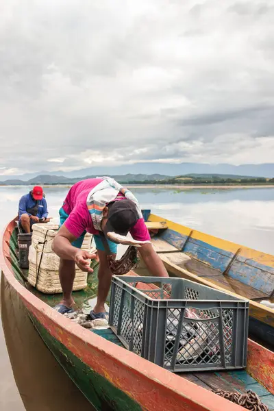 Yaguara, Huila, Kolombiya - 26 Ocak 2025 - Kolombiyalı bir balıkçı Betania Barajı 'ndaki kanonun tepesindeki sepete balık atıyor