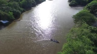 Neiva, Huila, Kolombiya 'da güzel bir günbatımında Magdalena Nehri' nde iki kano yüzüyor. Turizm, iş ve çevre kavramları