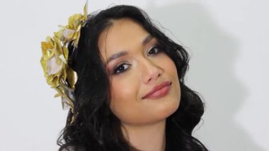 Kolombiyalı güzel bir kadın gülümseyip kameraya bakarken Neiva, Huila, Kolombiya 'daki bir stüdyoda beyaz bir arkaplan görüyor. Mutluluk ve güzellik kavramı