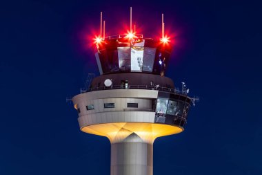Salzburg, Austria - January 27, 2024: Air traffic control tower at Salzburg airport tower at night with futuristic lights and architecture clipart