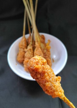 Selective focus. Indonesia street food called Sempol or Sempolan. It is a popular snack from javanese region made from chicken and tapioca flour and eggs, then put it on a skewer like a satay.  clipart