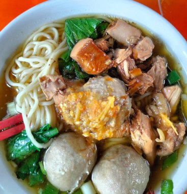 Mie Ayam Bakso adında bir kase geleneksel şehriye. Mie Ayam Bakso 'nun en üst açısı köfteli beyaz kasede.. 