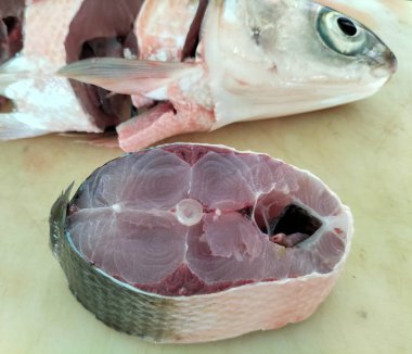 Süt balığı, alabalık, biftek, kesme tahtasında bir dilim taze çiğ balık. Seçici odak.