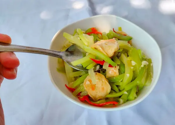 Seçici odaklanma. Sayur Labu Siyam veya Manisa veya Jipang veya Chayote. Endonezya yemeği. Sayur Godog Labu Siem beyaz arka planda izole edilmiş bir kasede servis yapıyordu. Üst görünüm.