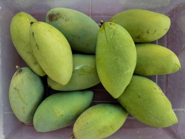 Seçici odaklanma. Piyasada mevsimlik Endonezya mangosu. Kutularda yeşil mango. Bir sürü yeşil mango. Büyük mango. Endonezya 'da mango sezonu.