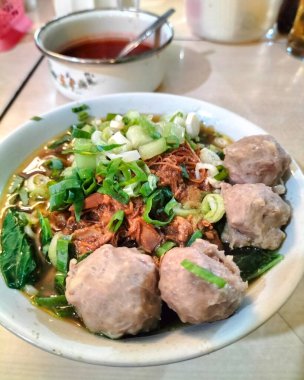 Mie Ayam Bakso adında bir kase geleneksel şehriye. Mie Ayam Bakso 'nun en üst açısı köfteli beyaz kasede.. 