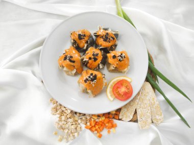 Japon Mentai soslu Dimsum. Beyaz tabakta servis edilmiş. Tempeh, tavuk ve siyah mürekkepbalığından yapılmış degiştirilmiş gamsum. Kapat ve seçici odak resmi.