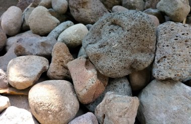 Seçici odaklanma. Nehir kenarında farklı renk ve boyutlarda taşlar var. Limbangan, Endonezya.