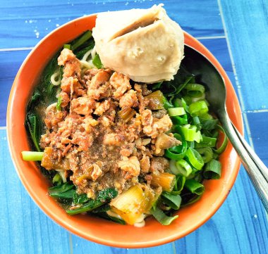 Mie Ayam Bakso adında bir kase geleneksel şehriye. Mie Ayam Bakso 'nun üst köşesi köfteli kahverengi bir kâse üzerinde.. 