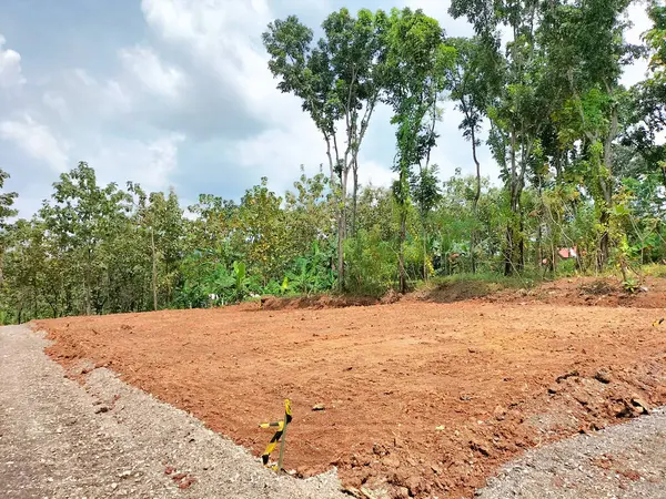 Land plot for housing construction project with car tire print in rural area and beautiful blue sky with fresh air . Land for sales landscape concept.