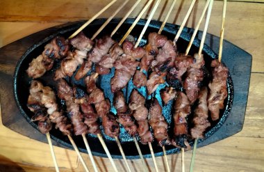Yakın plan. Elektrikli ocakta kambing ya da keçi satay. Yeşil biberli soya sosu, domates ve soğan dilimleri ile servis edilir.. 