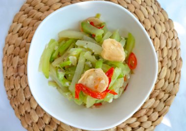 Beyaz bir kasede servis edilen sotelenmiş balkabağı sebzelerinin fotoğrafı. Beyaz arkaplan ile izole edilmiş. Seçici odak.