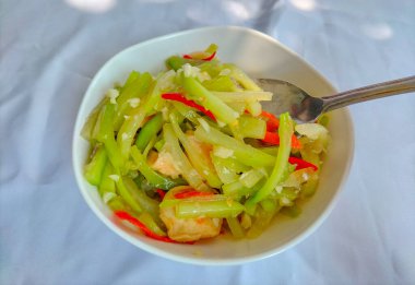 Beyaz bir kasede servis edilen sotelenmiş balkabağı sebzelerinin fotoğrafı. Beyaz arkaplan ile izole edilmiş. Seçici odak.