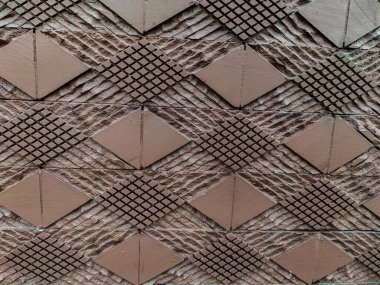 Ofis binasının dışındaki taş duvar motifleri. Rhombuslar tüm arka planı dolduruyor. Duvar kağıdı. Yakın plan..