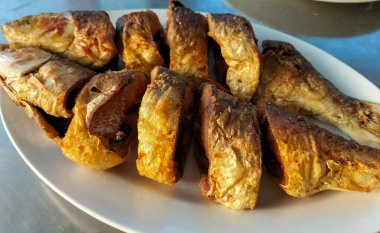 Kızarmış Süt Balığı, Endonezya ev yemeği olarak zerdeçal baharatıyla kızartılmış. Tabakta servis edilmiş. Seçici odak.