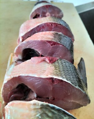 Süt balığı, alabalık, biftek, kesme tahtasında bir dilim taze çiğ balık. Seçici odak.