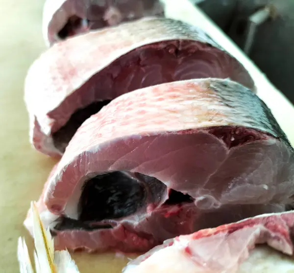 Süt balığı, alabalık, biftek, kesme tahtasında bir dilim taze çiğ balık. Seçici odak.