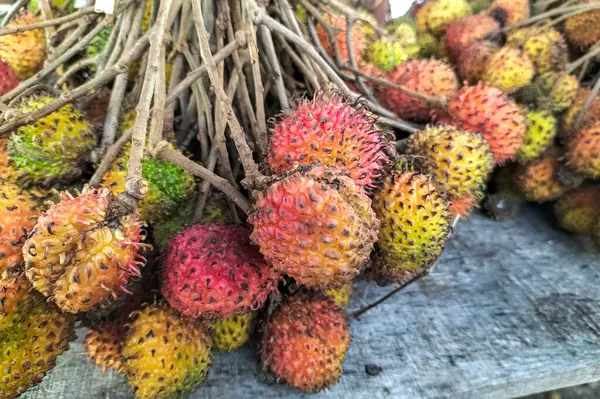 Asyalı Rambutan meyvesi. Endonezya 'nın Ungaran kentindeki geleneksel bir pazarda satılan Rambutan meyvesi yığını. Seçici odak.