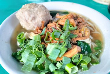 Mie Ayam Bakso adında bir kase geleneksel şehriye. Mie Ayam Bakso 'nun en üst açısı köfteli beyaz kasede.. 
