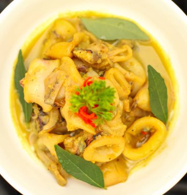 Gulai Cumi ya da kalamar hindistan cevizi sütüyle sarı baharat pişirmişler. Uzmanlık alanları Padang, Batı Sumatra Endonezya. Seçici odak.