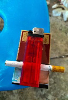 Gudang Garam markalı bir paket sigara ve cırcır böceği marka gaz çakmağı. Gudang Garam Endonezya 'nın en büyük sigara üreticilerinden biridir.. 