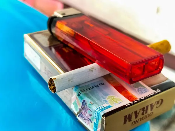 グダンガラムのブランドとクリケットブランドのガスライターを備えたタバコのパック グダン ガラムはインドネシア最大のタバコメーカーの一つです — ストック写真