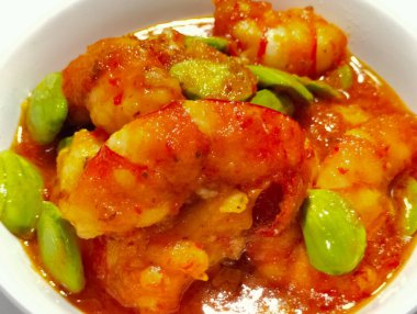 Petai ya da Pete karidesli, püre kırmızı biberli. Bu yemeğin adı Balado Udang Pete, akşam yemeği hazırlarken izole edilmiş. Seçici odak.