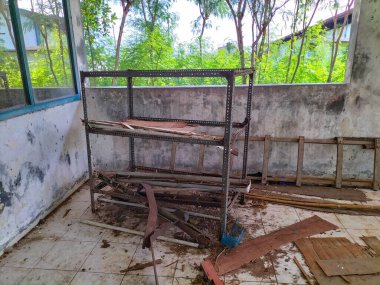 Seçici odaklanma. Su yağmuru hasarı yüzünden paslanan bir depoda paslanmış palet rafları..