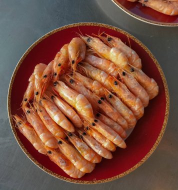 Kızarmış karides. Kızarmış karidesler kırmızı tabakta izole edilmiş. Seçici odak.