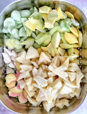 Paslanmaz çelik bir kutuda soyulmuş ananas, jicama, salatalık ve kedondong..