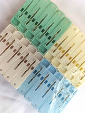 Beyaz arka planda çok renkli mandallar seti. Çamaşırlar için çok renkli plastik mandallar. Seçici odak.