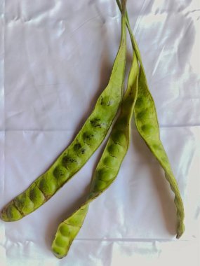 Yakın plan. Beyaz izole edilmiş arka planda Petai veya Raw Bitter Bean veya Raw Stink Bean. Güzel kokulu sebze..