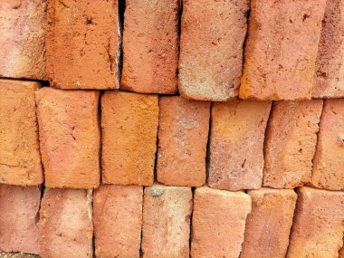 İnşaat malzemeleri yığını görüntüsü, inşaat için yeni kırmızı tuğlalar doğru bir şekilde bir araya getiriliyor. Kırmızı tuğlalar güneş ışığı arka planında yığılır. 