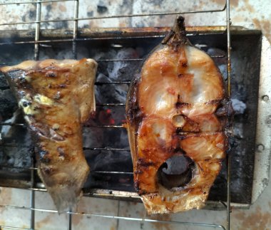 Mangalda sarımsak ve baharatla ızgara sütçü balığı yakın. seçici odak.